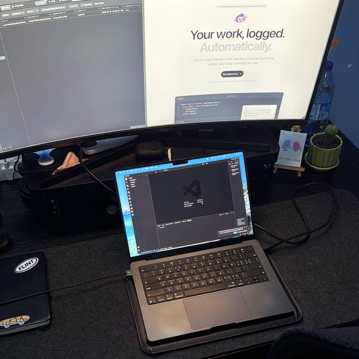 The desk in daylight, a laptop on a stand in front of an ultrawide monitor.